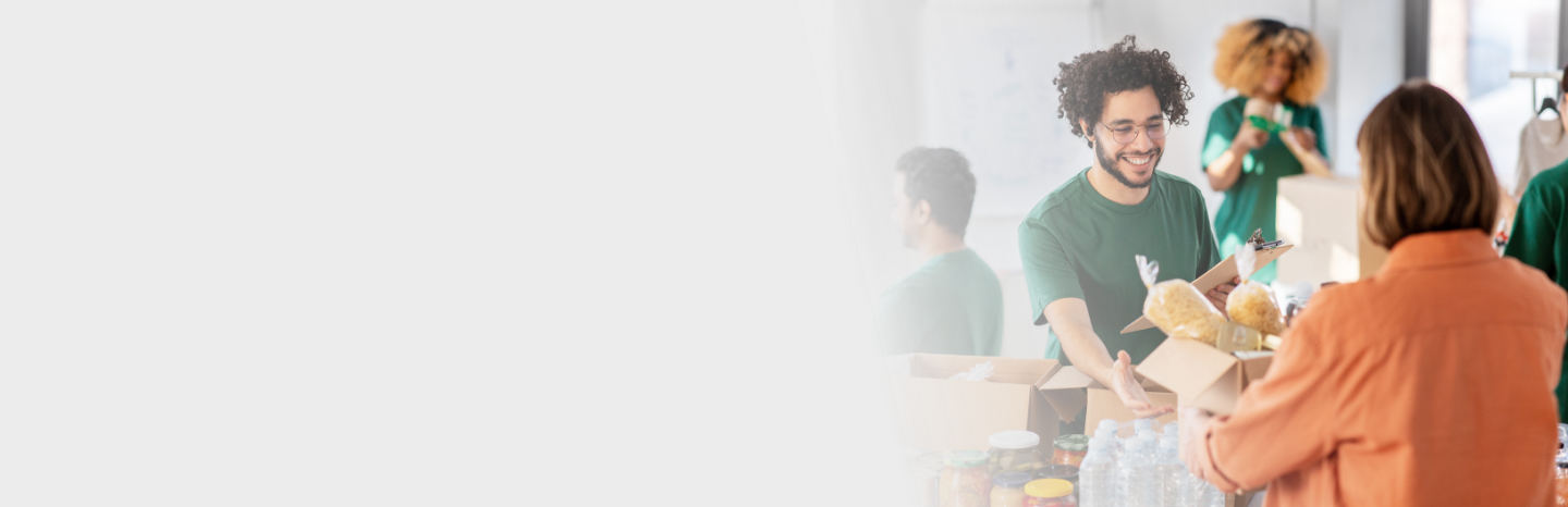 Young man taking in a food donation from a woman