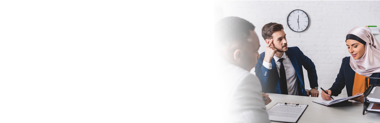 Woman signing papers in front of two lawyers