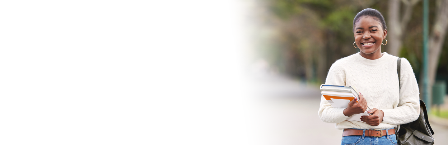 Young woman wearing a backpack and holding books outside.