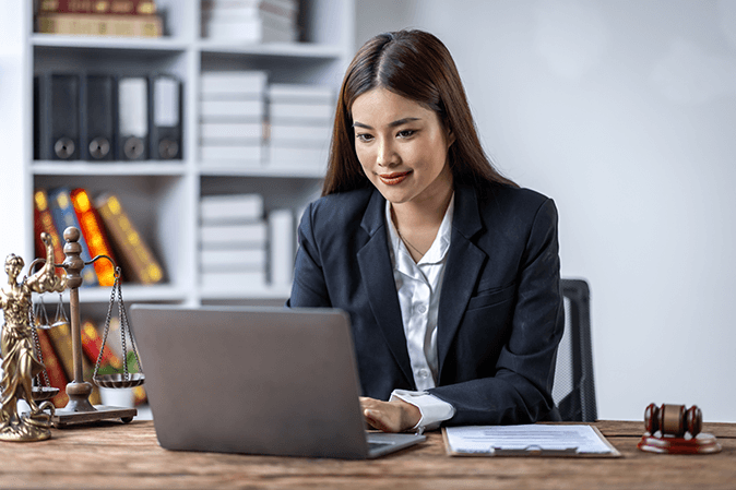 Young woman in business attire using a laptop 
